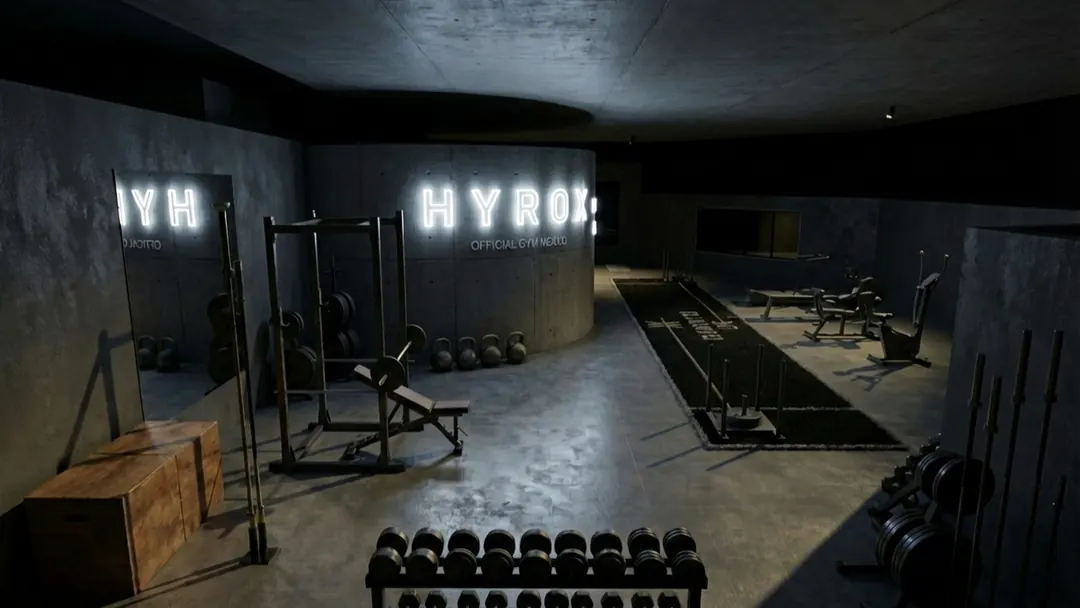 The development's HYROX affiliated gym, with rack, dumbbells, kettlebells and the sled lane on artificial turf